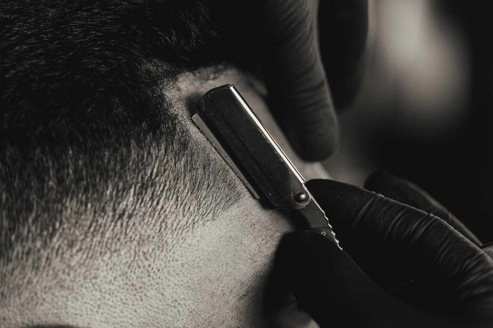 A straight razor cleaning up the hairline behind the ear.