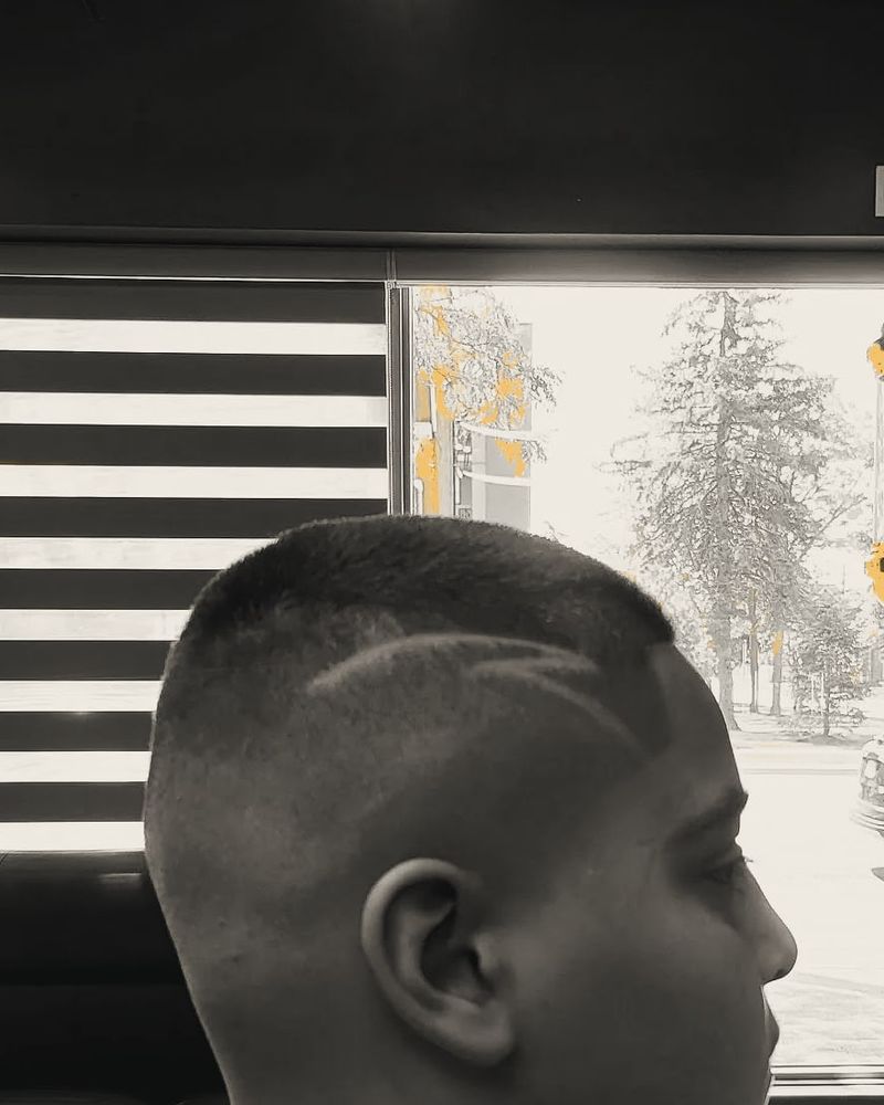 A boy with a short buzz cut and two curved lines shaved into the side as a design.