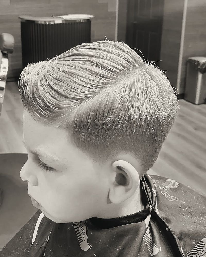 A blond boy with a neat side part and tapered sides.
