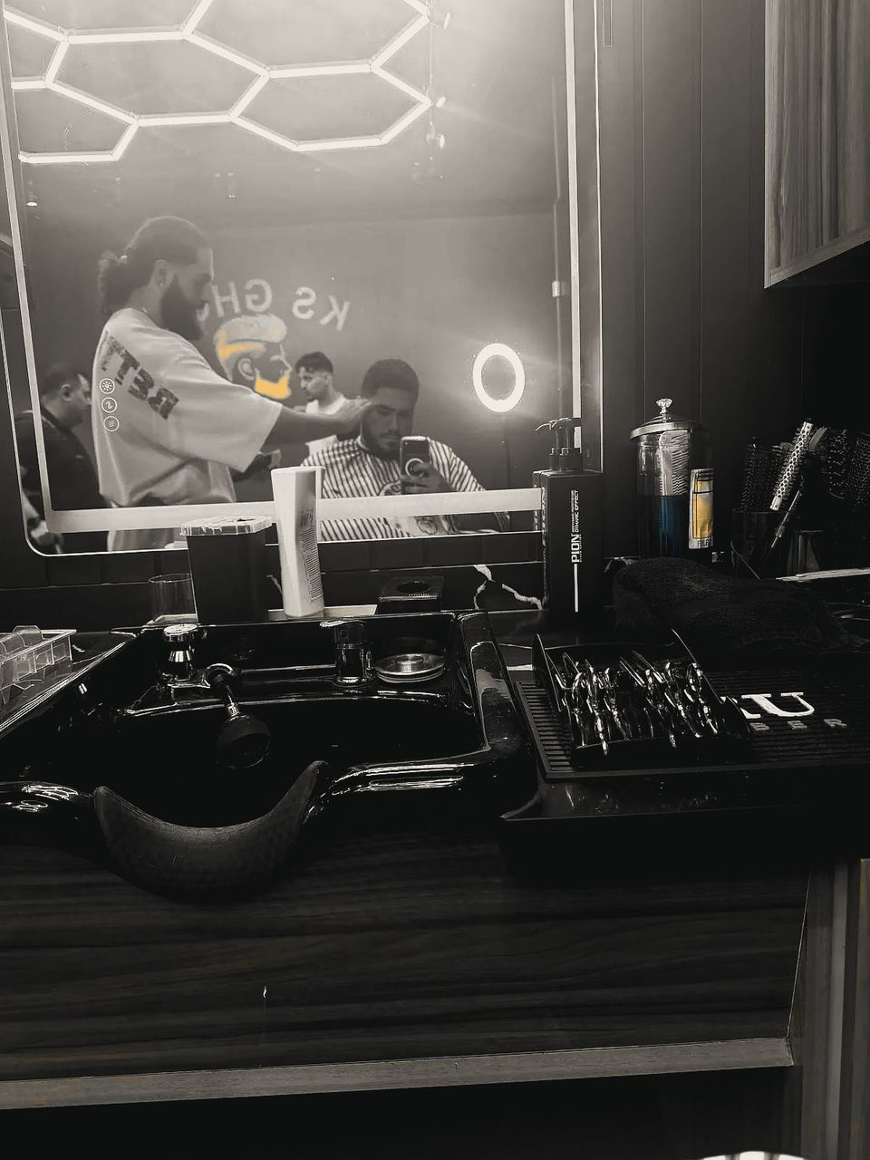 A cut in progress reflected in a KS Ghost mirror, with tools laid out on the counter.