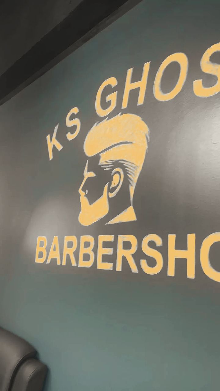 The KS Ghost Barbershop logo painted in gold on the shop’s teal wall.