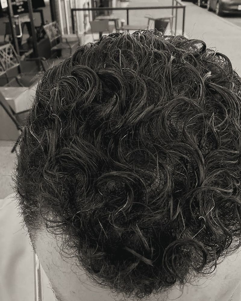 Dense curly hair photographed from above after a cut.